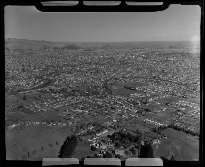 Burwood looking towards Christchurch City Centre, Canterbury Region, including Christchurch Golf Club (bottom right), grand house and gardens on Horseshoe Lake Road (foreground) and Shirley Boys' High School, 1951