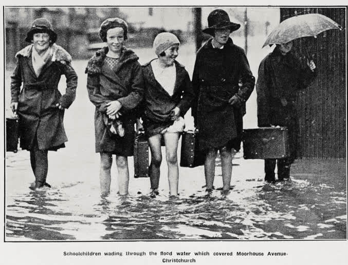 Schoolchildren wading through the flood water which covered Moorhouse Avenue, Christchurch, 1936