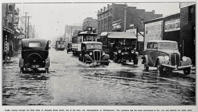 Traffic moving through the flood water in Colombo Street North, one of the main city thoroughfares in Christchurch, 1936