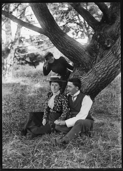 Man and woman seated in Hagley Park, 1900