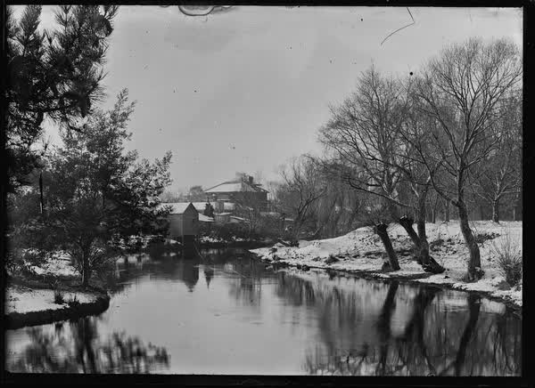 Buildings along the Avon River in snow, 1900