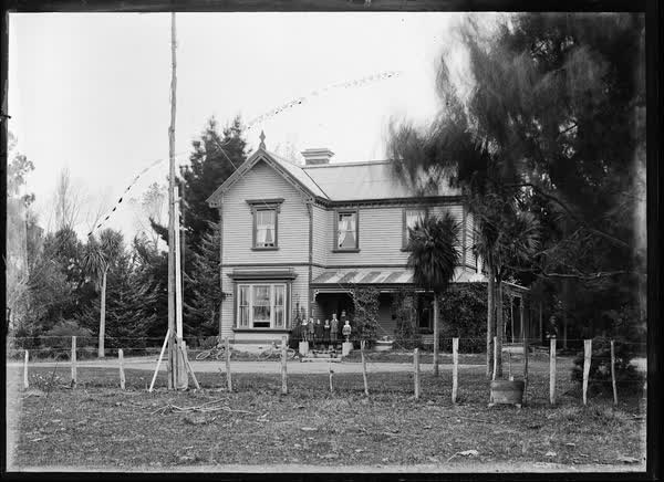Man with children on front steps of a house, 1900