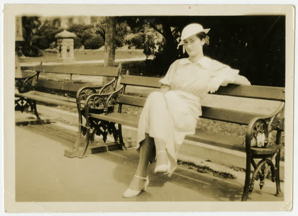 Miss Joyce Macaulay on a park bench, 1930