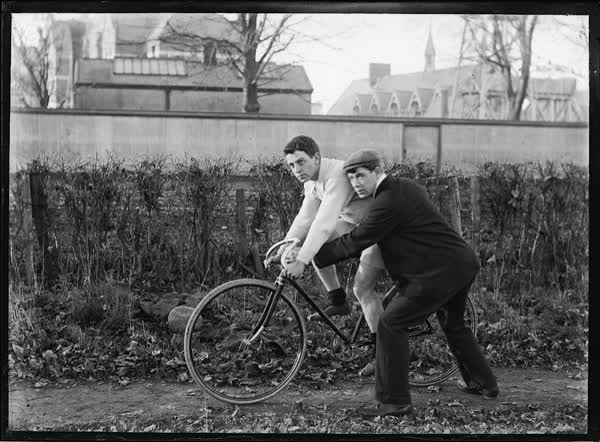 Two men and a bicycle by Christchurch Hospital, 1900
