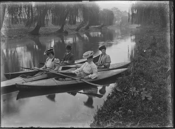 Three women and one man in canoes on the Avon River, 1900