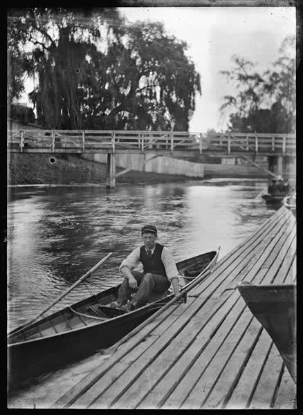 Man in a rowboat by the Antigua Boat Sheds, 1900
