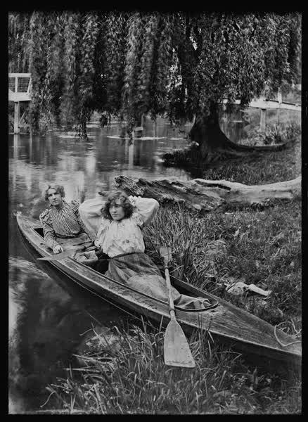 Two women in a rowboat by a weeping willow, 1900
