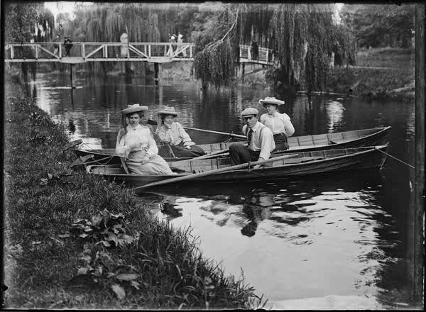 Three women and one man in rowboats on the Avon River, 1900