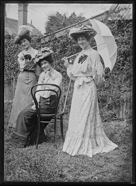 Three women in a garden, 1900