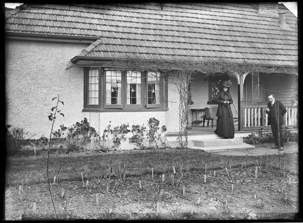 Man standing in garden with a woman, 1900