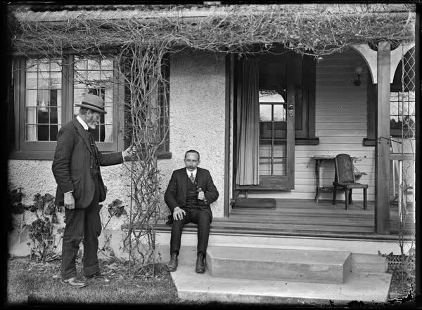 Two men on the steps of a house, 1900