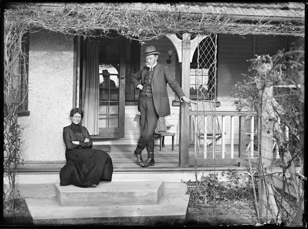Man and woman outside a house, 1900