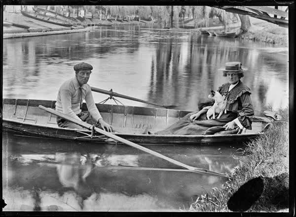 Man and a woman with a small dog in a rowboat on the Avon River, 1900