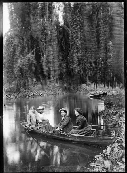 Three women and a man in a double rowboat on the Avon River, 1900