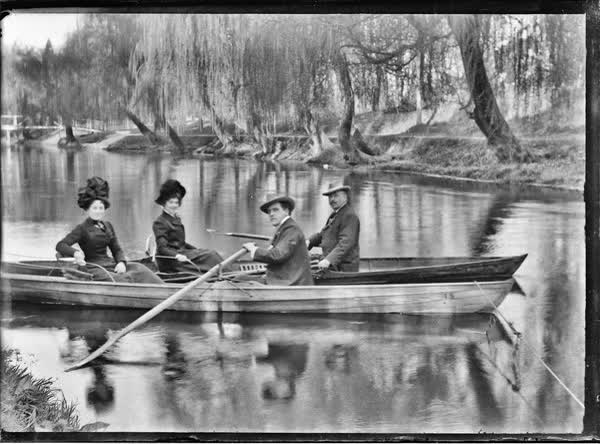 Two men and two women in tethered rowboats on the Avon River, 1900