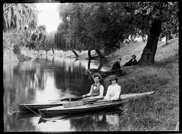 Young man and woman in canoes on the Avon River, 1900
