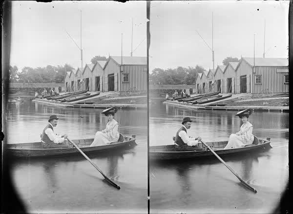 Man and woman in a rowboat by the Antigua Boat Sheds, 1900