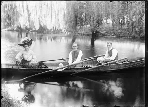 Two men and a woman in a double rowboat on the Avon River, 1900