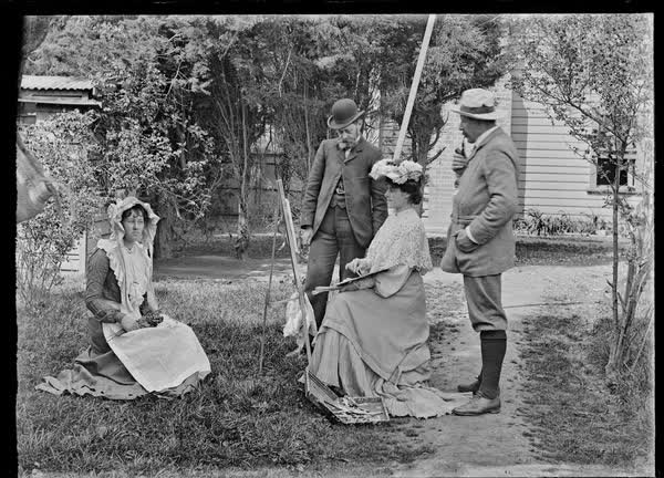 Two men and two women in a garden, 1900