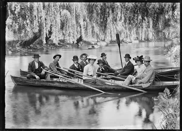 Eight men and two women in canoes and rowboats, 1900
