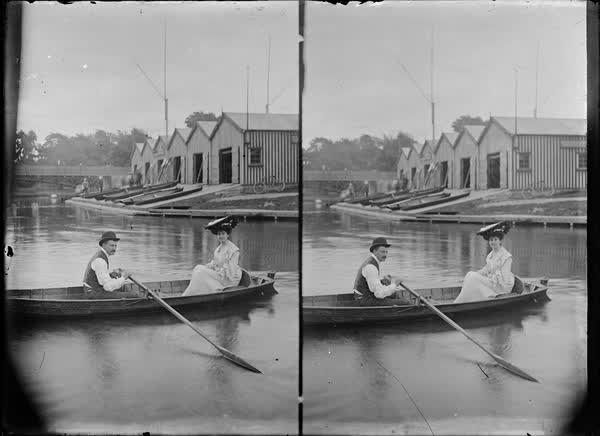 Man and woman in a rowboat near the Antigua Boat Sheds, 1900