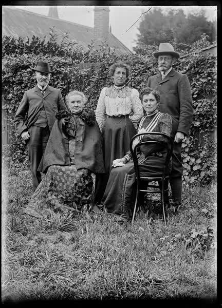 Three women and two men in a garden, 1900