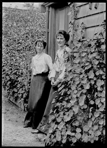Two women standing in a doorway, 1900
