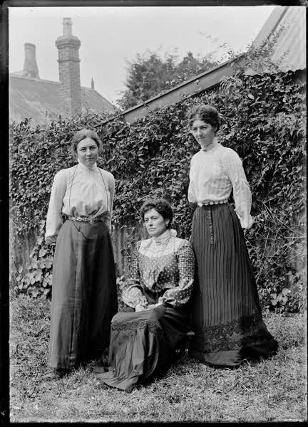 Three women in a garden, 1900