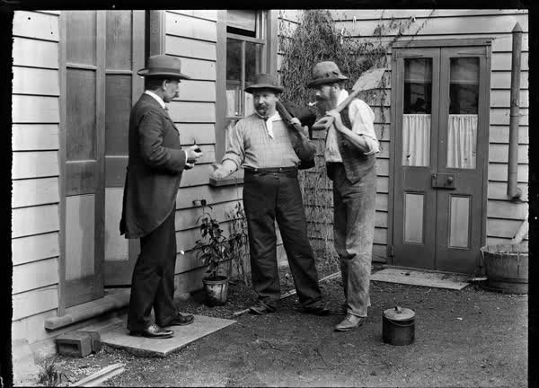Three men outside a weatherboard house, 1900
