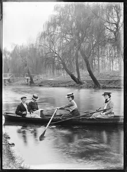 Three women and a man in a double rowboat on the Avon River, 1900