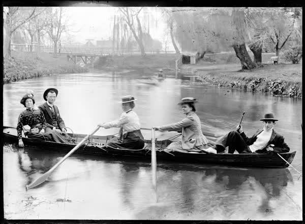 Three women and two men in a double rowboat, 1900