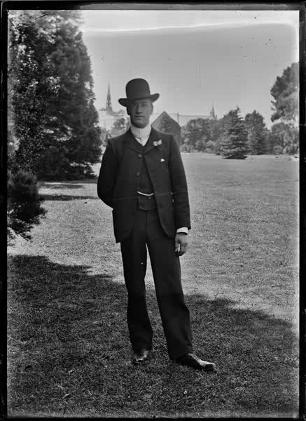 Man standing in a grassed area, 1904
