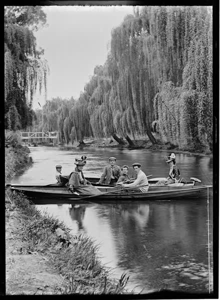 Four men and two women in rowboats and a canoe, 1900