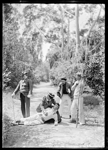 Four men and a woman on a path amongst trees, 1900