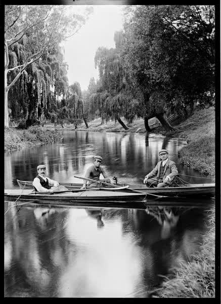 Three men in a rowboat and canoe, 1900
