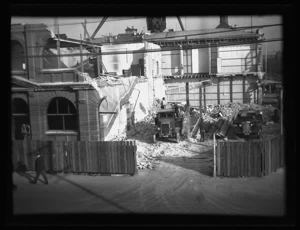 Trucks and workers at MED demolition site, 1937