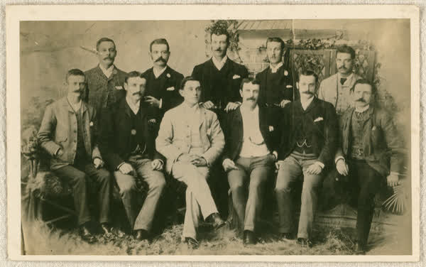 Eleven men in a garden themed studio, 1890