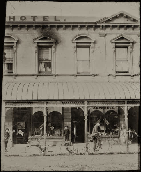 Three unidentified males outside A. E. Preece’s Cyclists’ Exchange, 1885