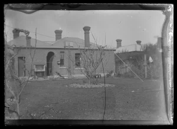 Backyard of a brick house, 1900