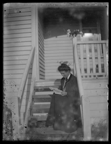 Woman reading on the stairs, 1900