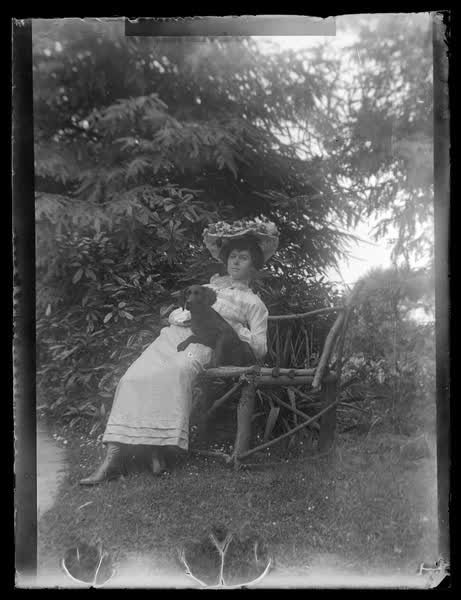 Young woman sitting by a tree, 1900