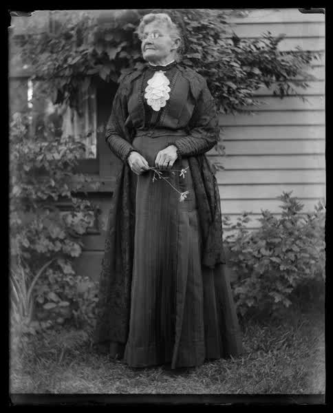 Elderly woman standing, 1900