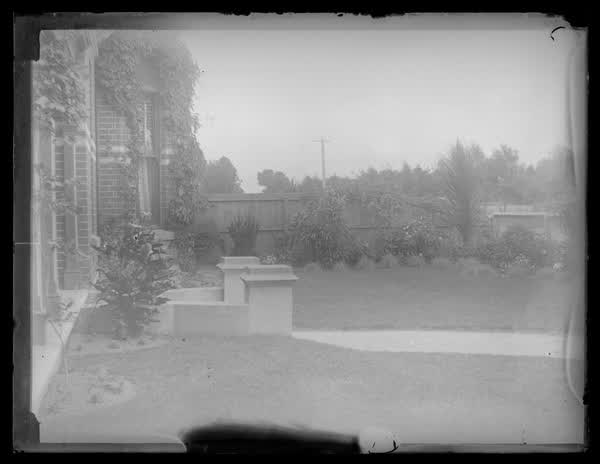 Garden of a brick house, 1900