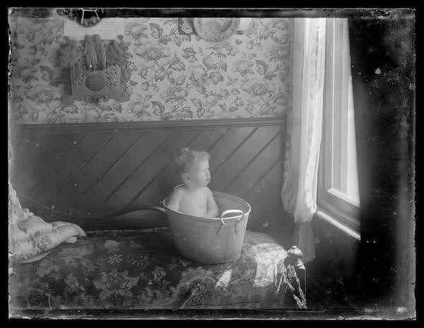 A baby in a tin bath, 1900