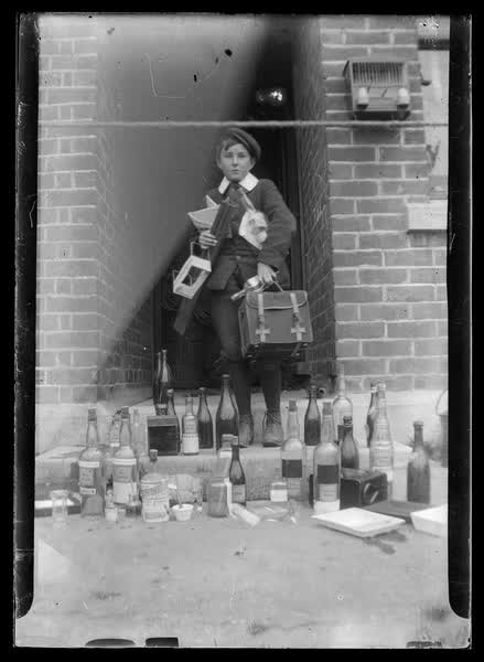 Young boy with glass bottles, 1900