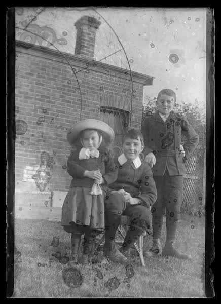 Three children in a garden, 1900