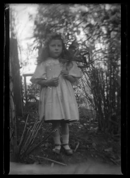 Young girl holding a flower, 1900