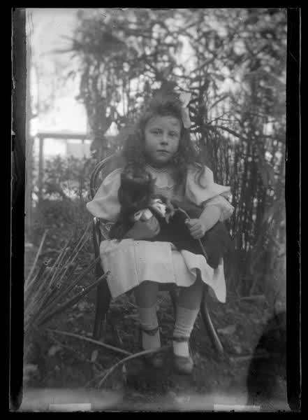 Young girl holding a cat, 1900