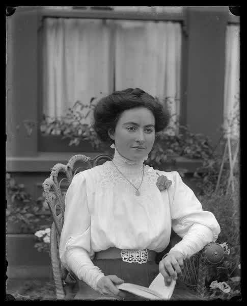 Young woman sitting in a garden, 1900