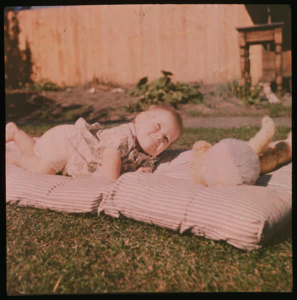 Baby and toy on a blanket, 1950